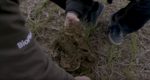 Close up of two people kneeling with soil
